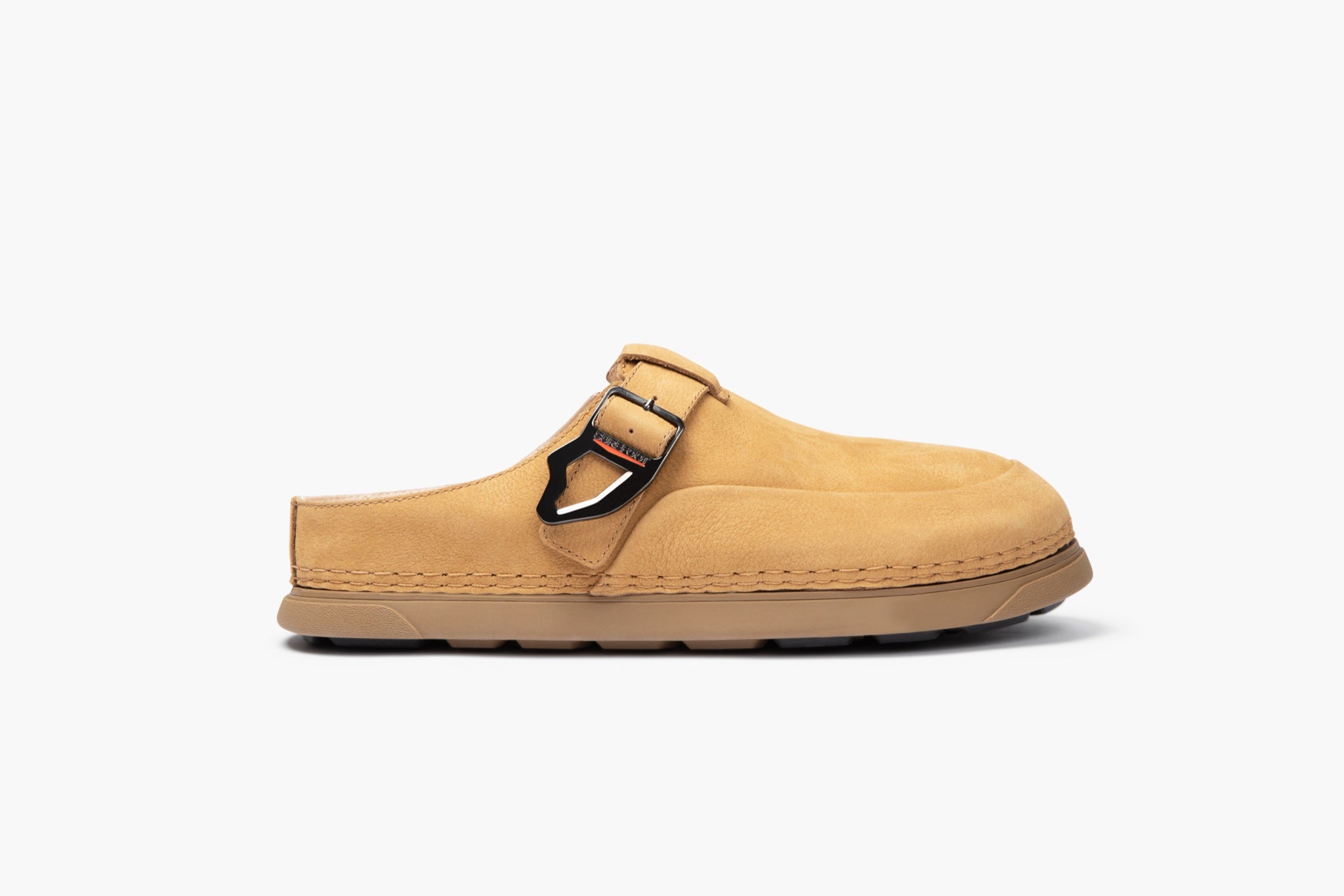 Tan clog shoe with a buckle on a white background